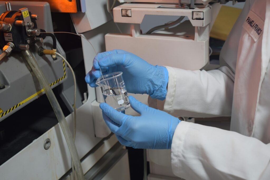 Close-up of a scientist handling a beaker with precision in a laboratory setting.